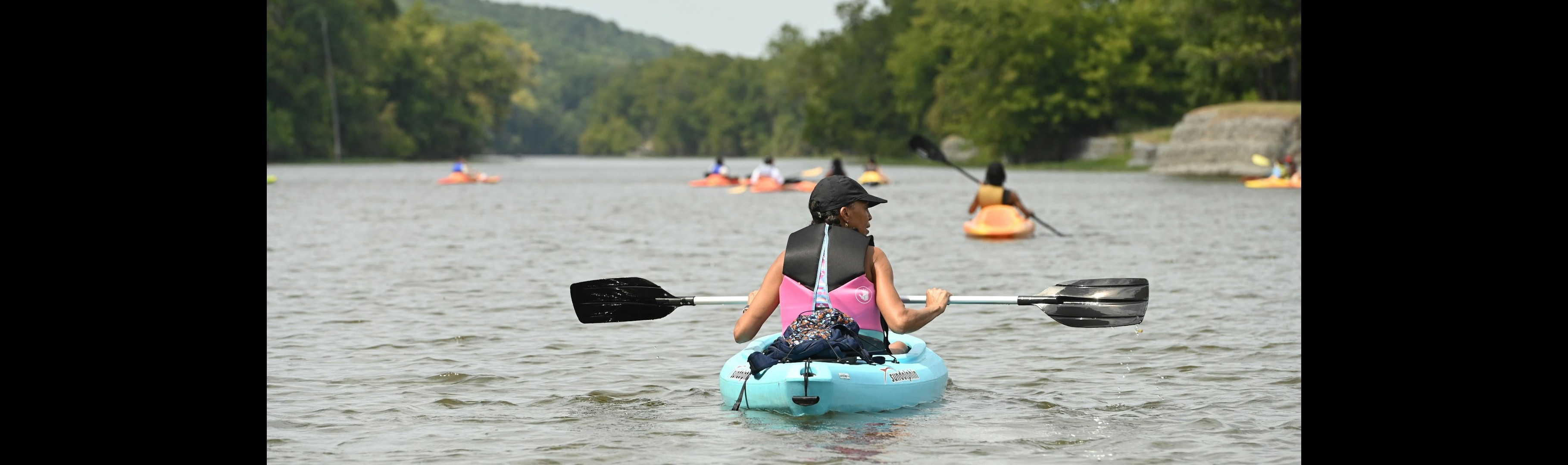 Group kayaking together on a calm river during an outdoor adventure